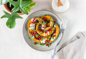 Grilled pumpkin with pomegranate and white sauce. Healthy eating.