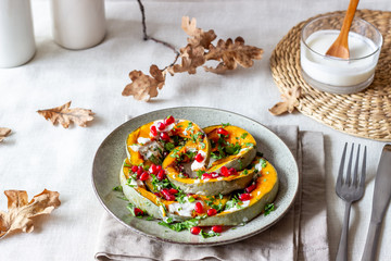 Grilled pumpkin with pomegranate and white sauce. Healthy eating.