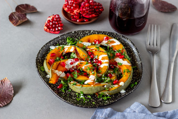 Grilled pumpkin with pomegranate and white sauce. Healthy eating.