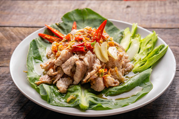 Spicy Lemon Pork , Pork with lemonade / Pork boil with chili and lime lemon sauce with herb and Vegetable on plate - Thai spicy food