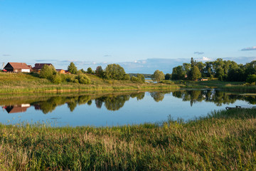 Fototapeta na wymiar Lake on the outskirts of the village on a summer evening at sunset