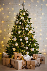 christmas tree and heap of gift boxes over white brick wall with lights