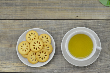 Fresh tea in cup with cookies on wooden table