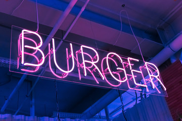 trendy neon illuminated letters burger  in the window of a fast food restaurant