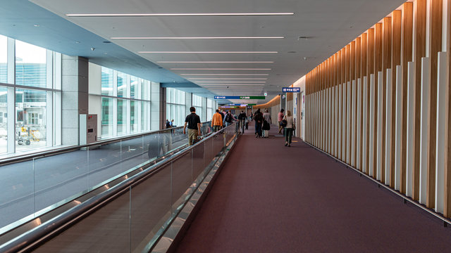 Incheon \ South Korea - 14 September 2019: People walking down the transit walkway in Incheon International airport. Horizontal elevator for speedy connection within terminal grounds.