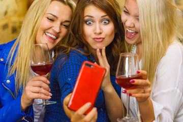 Girls in pub club taking self photo with phone