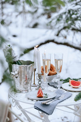 Romantic dinner in the winter forest.