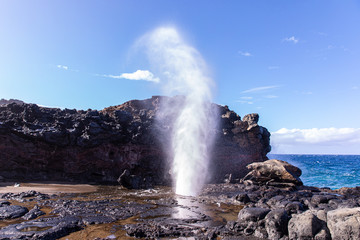 View at a stream of water and steam exploding from Nakalee blowhole, Maui, Hawaii