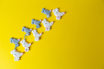 Marshmallows in the shape white and gray mice or rats on a yellow background,laid out diagonally. Background, copy space, close up