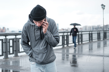 young man talking on the phone on a city street. © Oleg Samoylov