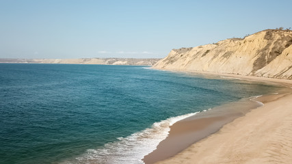 Aerial drone view of surfers beach, calm water and geology and typical vegetation of Angola