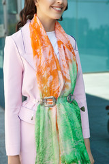 Cropped medium shot of a brunette lady wearing a pink coat in modern urban landscape. The wide...