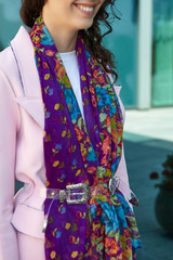 Cropped medium shot of a brunette lady wearing a pink coat in modern urban landscape. The wide...