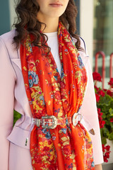 Cropped medium shot of a brunette lady wearing a pink coat in modern urban landscape. The wide...