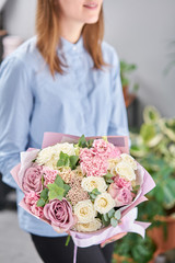 White and pink color. Beautiful bouquet of mixed flowers in womans hands. the work of the florist at a flower shop. Fresh cut flower.