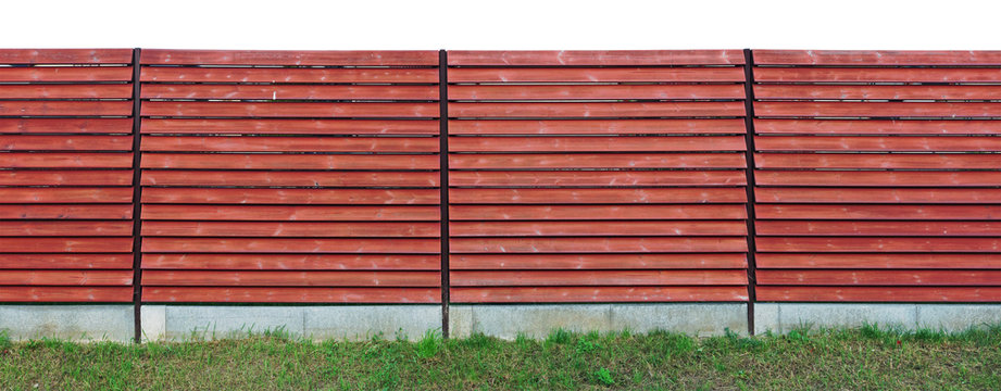 Long rustic wooden fence made of red horizontal boards isolated