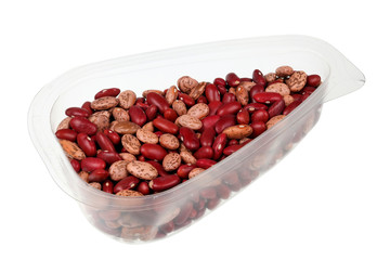 Daily food product - small red and motley dry  beans in a transparent plastic container  isolated macro