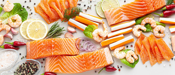 banner of fresh seafood on a table with spices, vegetables and olive oil: fresh and smoked salmon, shrimp and crab sticks for a supermarket or fish sushi restaurant.