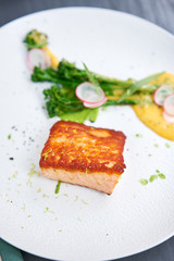 Salmon steak fillet and garnished with young broccoli. Restaurant menu, a series of photos of different dishes