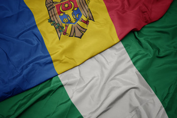 waving colorful flag of nigeria and national flag of moldova.
