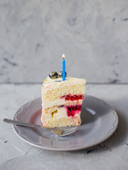 Slice of Birthday Cake with a lit candle and fork over a gray background. Girl cake, Bakery and...