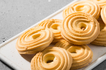 Cookies on a white ceramic plate on the gray kitchen table. Top view with copy space	