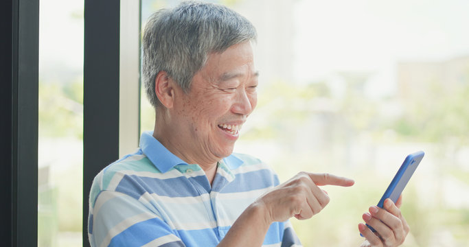 elder man use smart phone