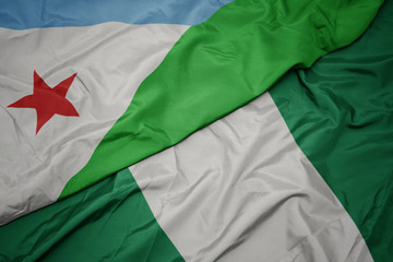 Obraz premium waving colorful flag of nigeria and national flag of djibouti.