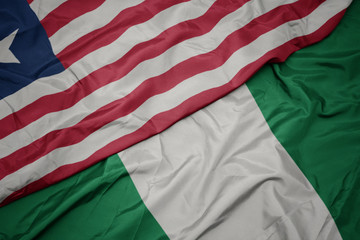 Obraz premium waving colorful flag of nigeria and national flag of liberia.