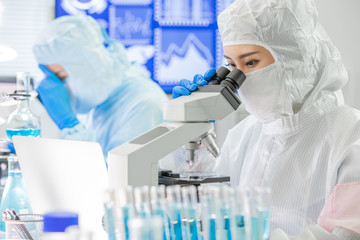 asian scientist use microscope
