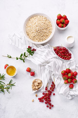 Oats with strawberries and red currants. Red-coloured still life. Flatlay with copy space