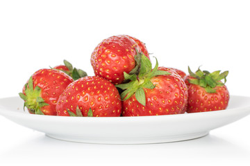 Lot of whole fresh red strawberry on white ceramic plate isolated on white background