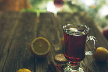 Christmas mulled wine with spices and fruits on wooden table