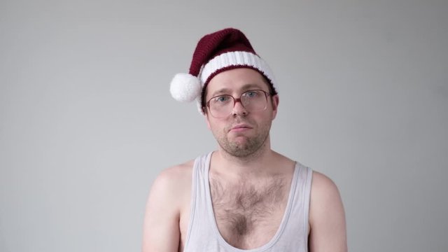Sad caucasian man in santa hat and big glasses