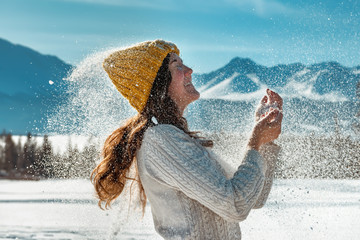 Happy girl plays with snow powder