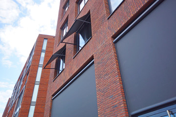 facade with windows of a modern red brick building in perspective