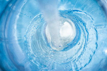 Background with a flowing stream of blue clear liquid