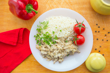 Beef stroganoff and rice close-up on a plate on the table. horizontal view from above