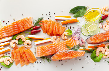 fresh seafood on a table with spices, vegetables and olive oil: fresh and smoked salmon, shrimp and crab sticks for a supermarket or fish sushi restaurant. © irynagrygorii