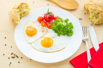 Fried Eggs on a plate on rustic wooden background