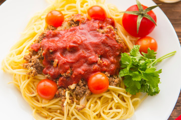 Spaghetti with tomato sauce on rustic wooden table
