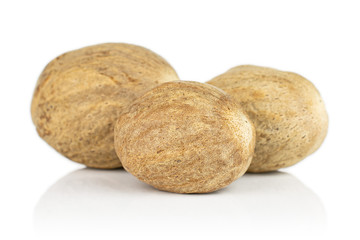 Group of three whole dry brown nutmeg isolated on white background