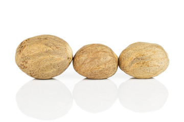 Group of three whole dry brown nutmeg in row isolated on white background