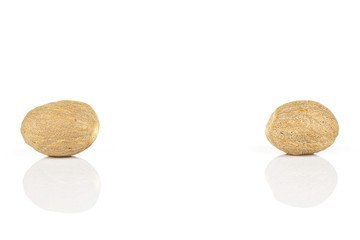 Group of two whole dry brown nutmeg isolated on white background