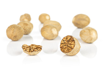 Group of eight whole one half one piece of dry brown nutmeg isolated on white background