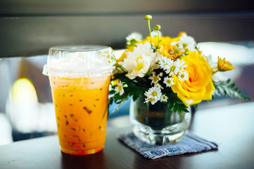 Iced coffee with iced Thai tea on the table paired with flower vases