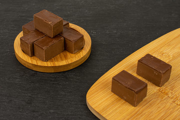 Lot of whole sweet brown viennese nougat on bamboo coaster on bamboo cutting board on grey stone