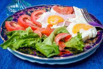 Fried eggs with tomatoes and lettuce