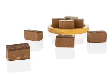 Group of eight whole sweet brown viennese nougat on bamboo coaster isolated on white background