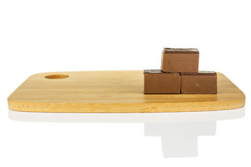 Group of three whole sweet brown viennese nougat on bamboo cutting board isolated on white background